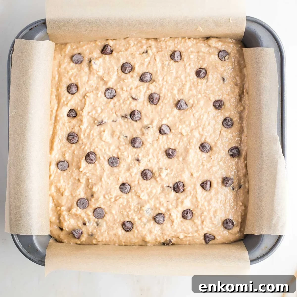 Square baking pan filled with blondies batter with chocolate chips. 