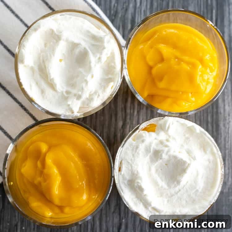 overhead shot of four cups of mango pudding, two with whipped cream, two without