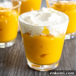 small cup of mango pudding without gelatin topped with whipped cream