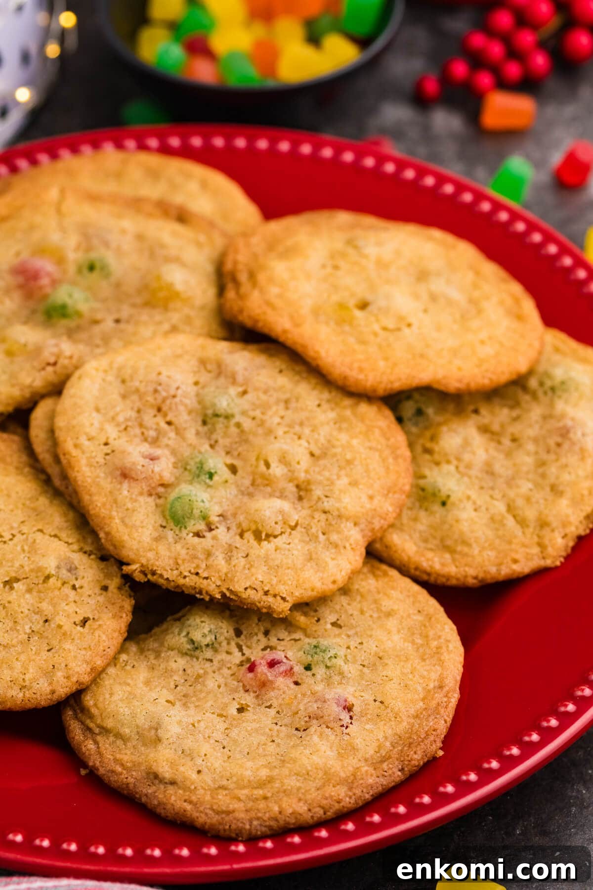 Gumdrop Cookie Recipe: Soft, Chewy Holiday Treats 5 Golden brown cookies with colorful gumdrop pieces on a red plate, surrounded by festive candy and holiday decor.
