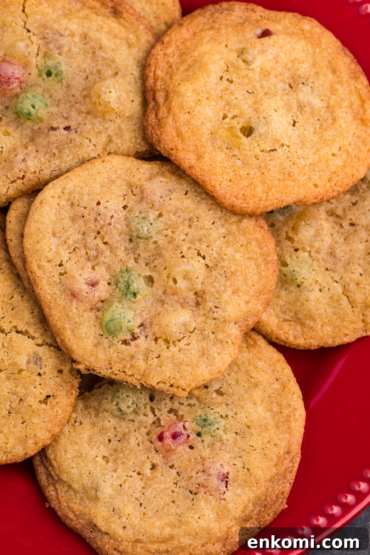 Gumdrop Cookie Recipe: Soft, Chewy Holiday Treats 6 Golden brown cookies with colorful gumdrop pieces on a red plate, surrounded by festive candy and holiday decor.