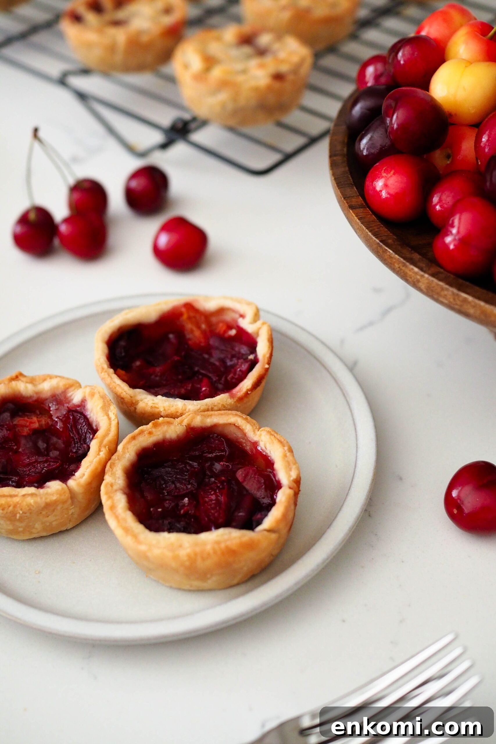 Mini Cherry Pies Recipe: Perfect Handheld Fruit Tarts 13 Three mini cherry pies without lattices on a plate.