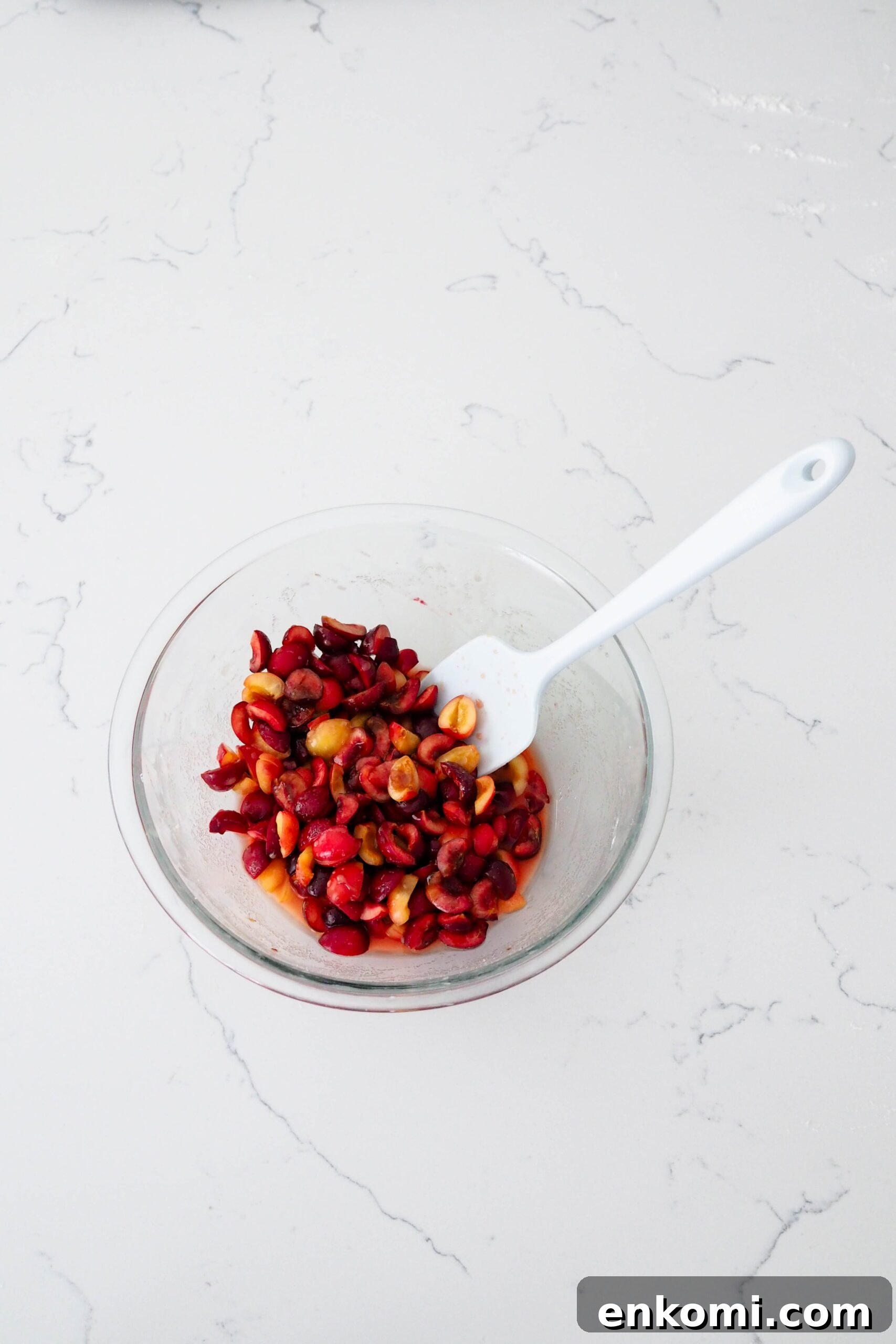 Mini Cherry Pies Recipe: Perfect Handheld Fruit Tarts 5 A bowl of macerated cherries on a quartz counter.