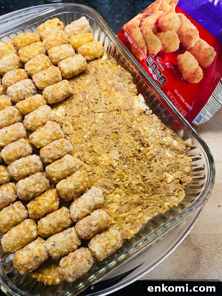 Cheesy Brisket and Tater Tot Casserole Recipe 5 adding the tots to the casserole