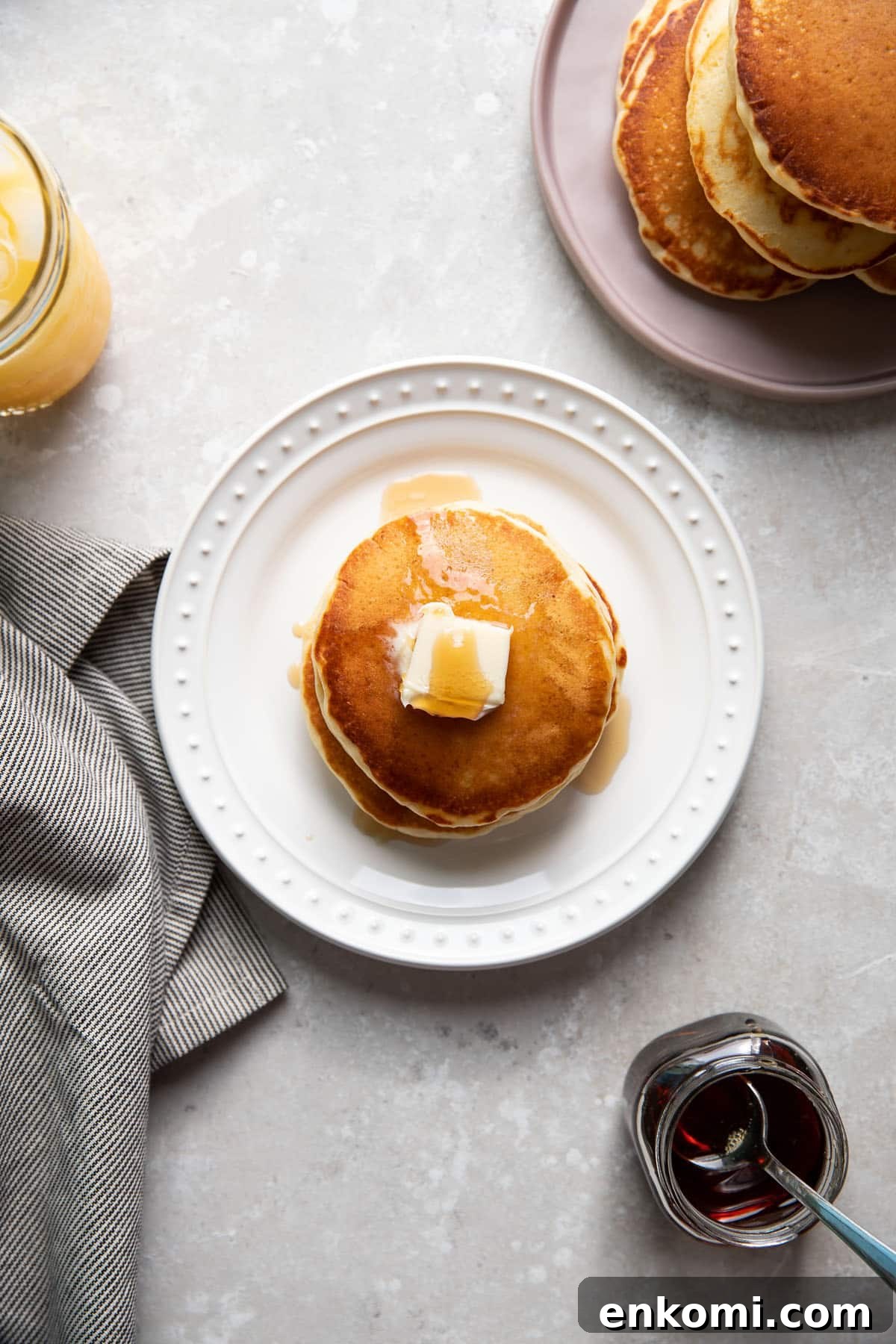 buttermilk pancakes on a plate with butter and maple syrup on top