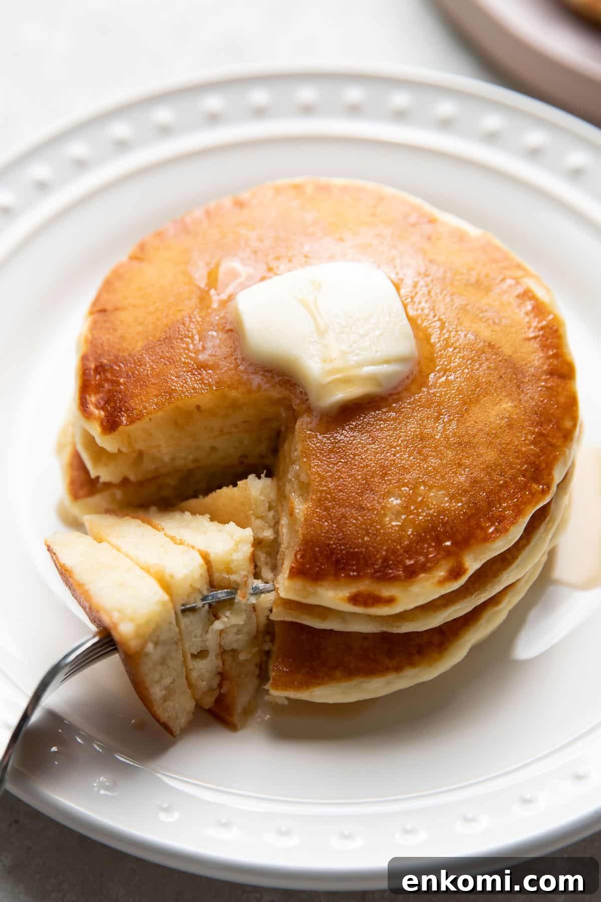 buttermilk pancakes on a plate with butter and maple syrup on top
