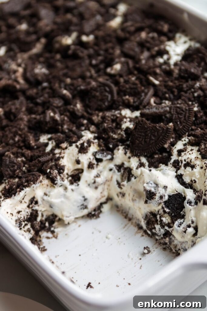 sliced Oreo dessert in a casserole dish with piece taken out 