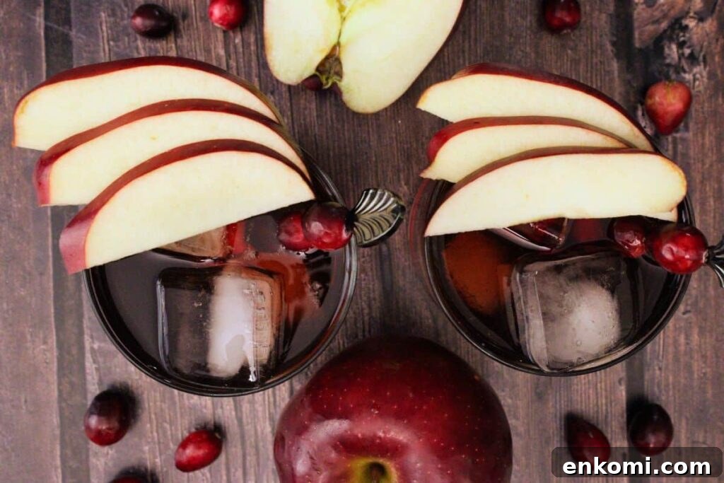 overhead view of two crownberry apple cocktails garnished with apple slices