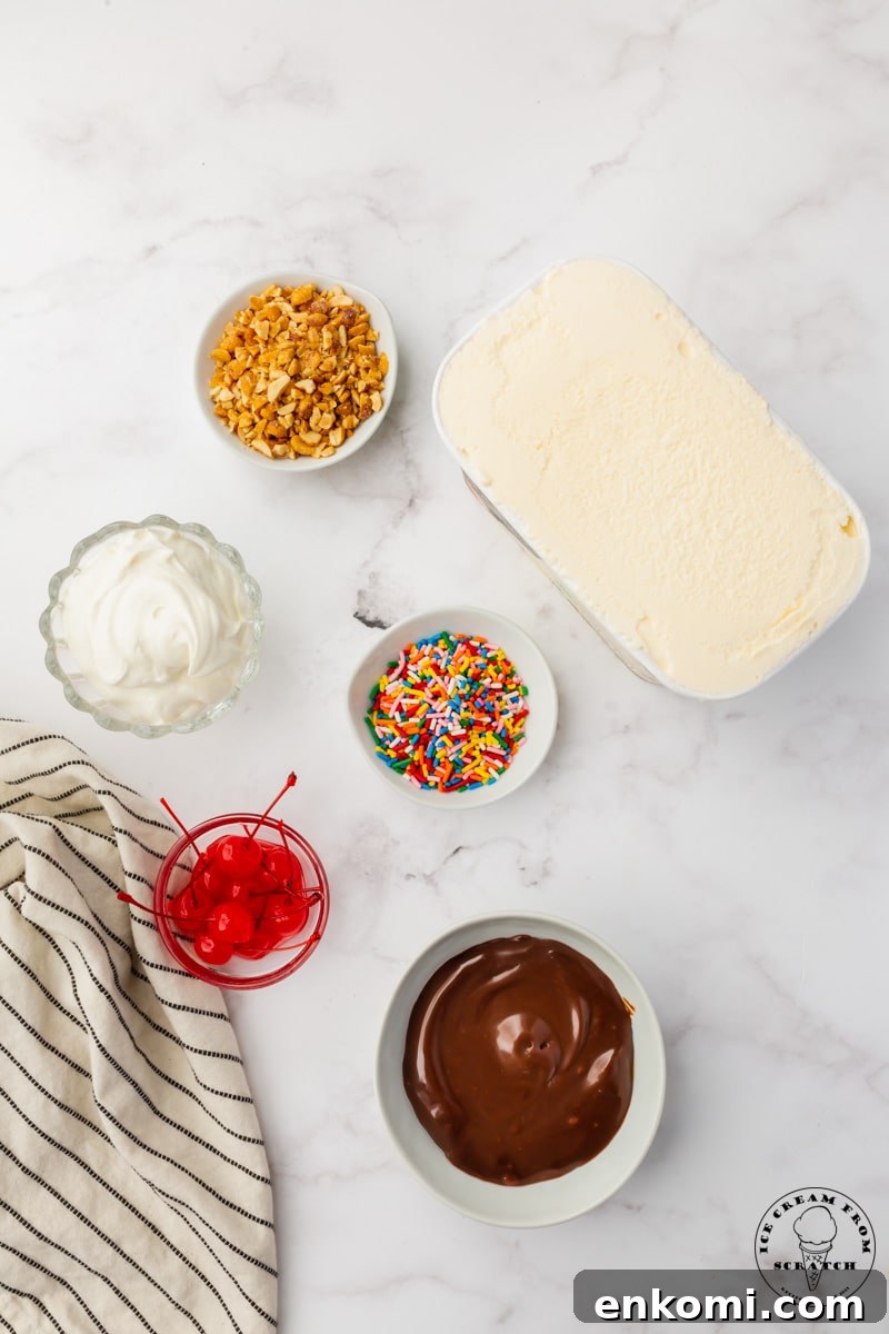 Decadent Hot Fudge Sundae Recipe You’ll Love 3 The ingredients needed to make a classic hot fudge sundae, all on a counter, viewed from above.