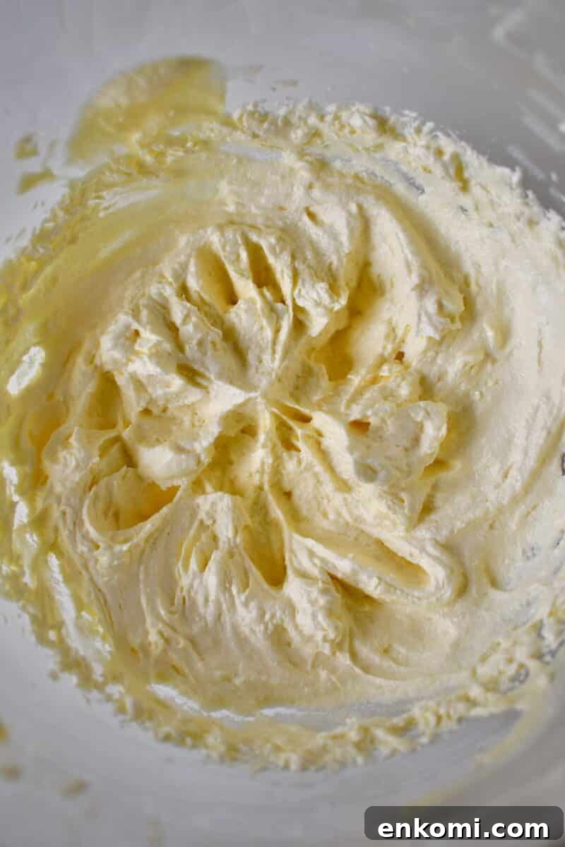 Decadent Banana Split Layer Cake Recipe 7 Whipped filling in a stand mixer bowl.