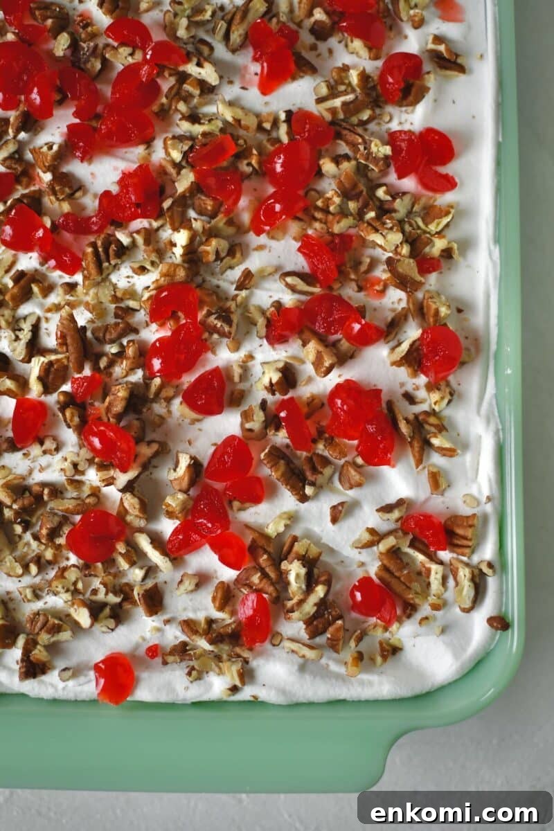 Decadent Banana Split Layer Cake Recipe 10 Finished Banana Split Cake in the baking dish, ready to be chilled. Topped with chopped cherries and pecans.