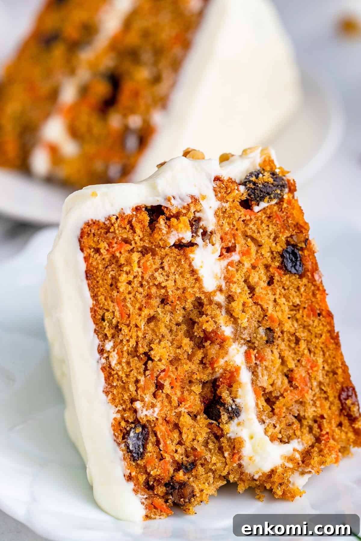 Close up of a slice of Layered Carrot Cake on white plate