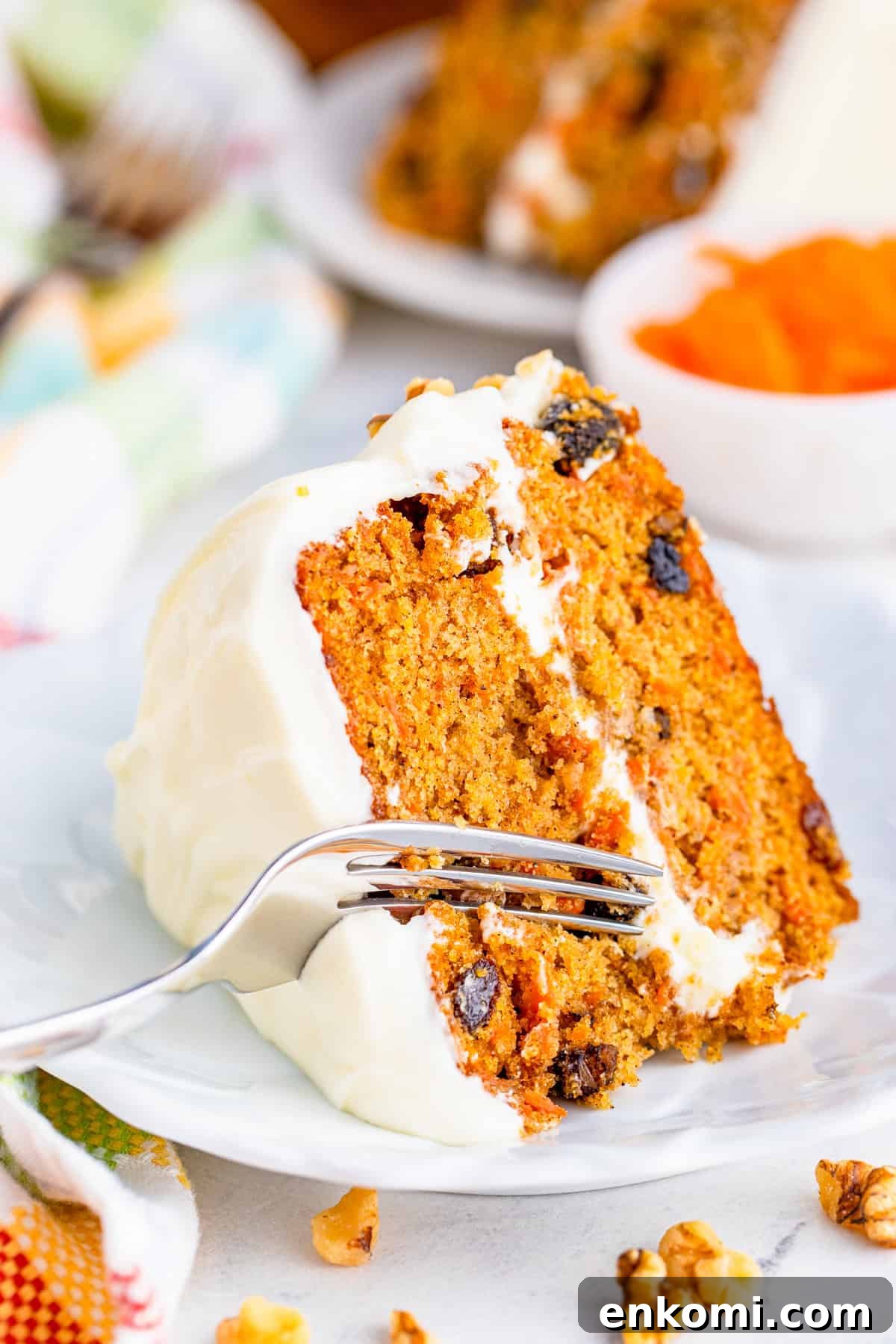 Fork cutting into slice of Layered Carrot Cake