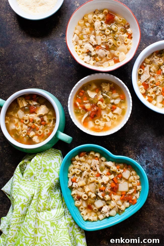 Chicken noodle soup in various shaped bowls with a green towel