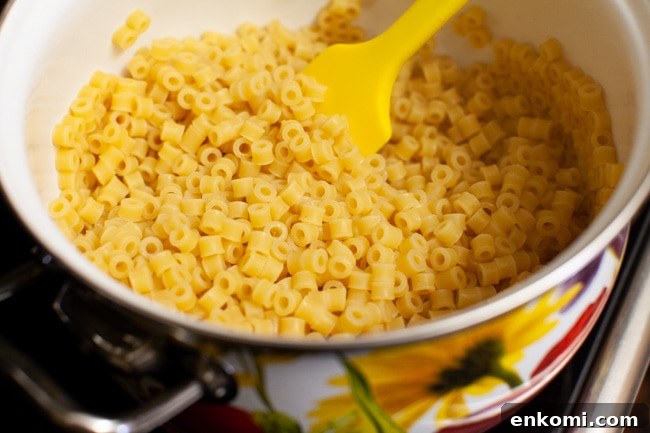 cooked pasta noodles in a pot with a rubber spatula