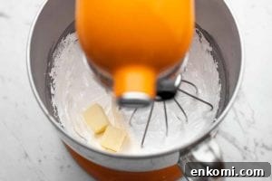 How to Make Silky Swiss Meringue Buttercream for Cakes and Cupcakes 5 Butter being whipped into Swiss meringue buttercream.