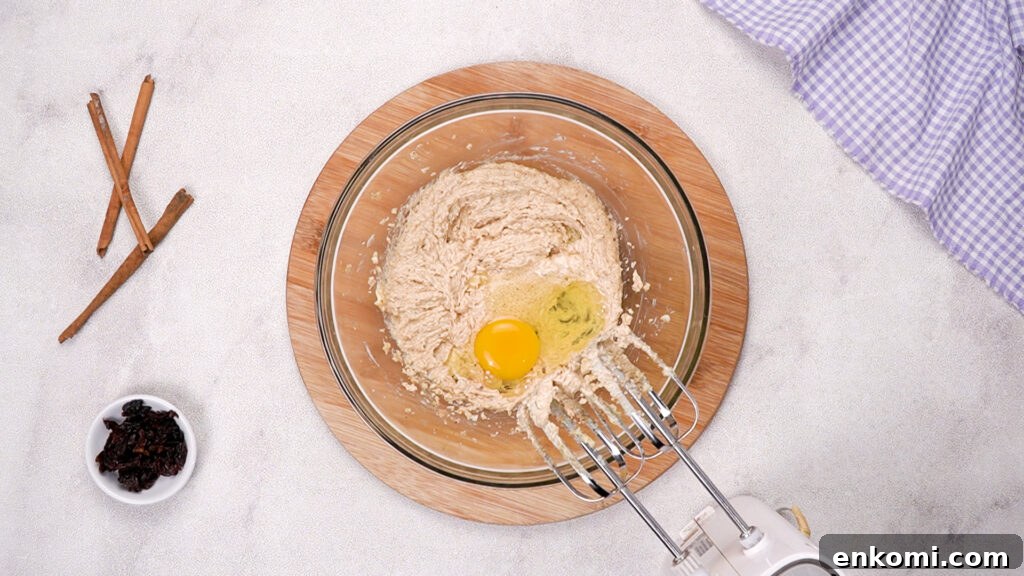 The mixture has been creamed; an egg sits in the bowl.
