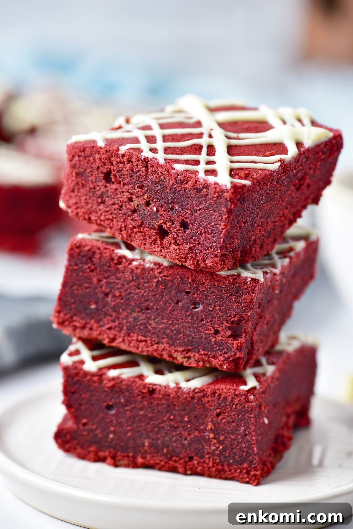 Red velvet brownies cut into squares and stacked on a small white plate. 