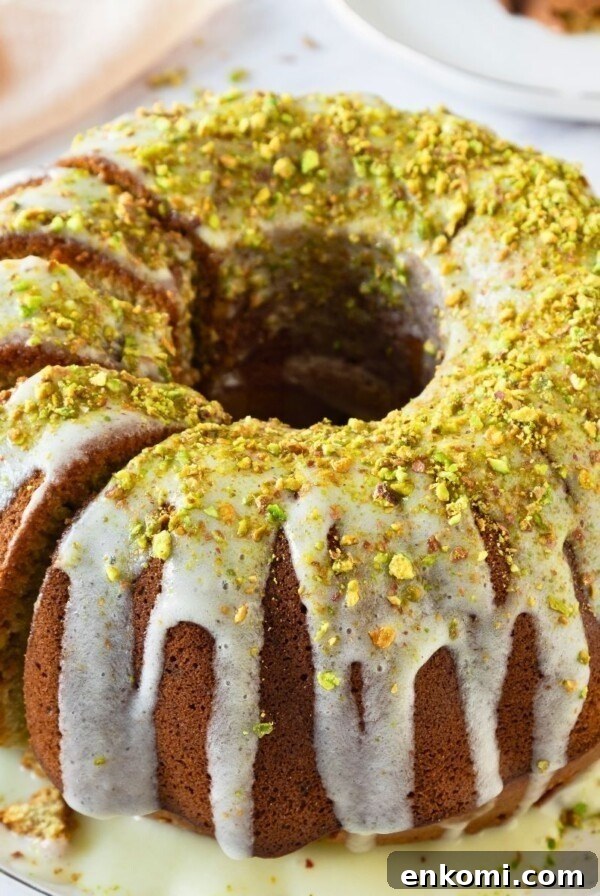 Bundt cake on a platter with a few slices made into the left side of the cake.