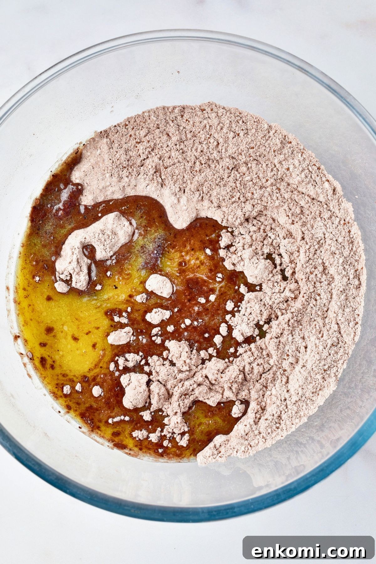 Ingredients being mixed in a large glass bowl. 