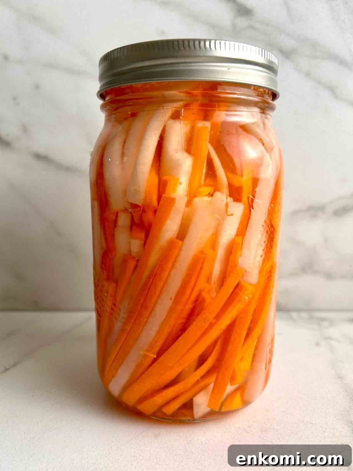 jar of pickled daikon and carrots with brine.