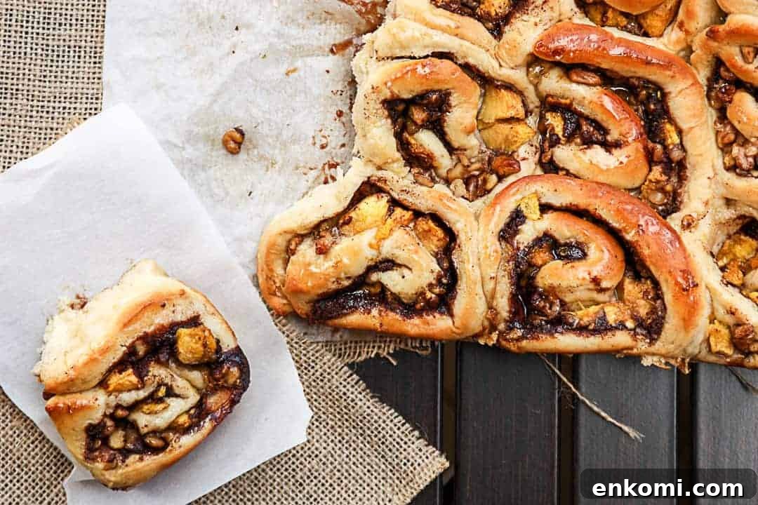 Peach Pecan Cinnamon Rolls with Sticky Glaze 5 Sweet rolls on parchment paper on a table