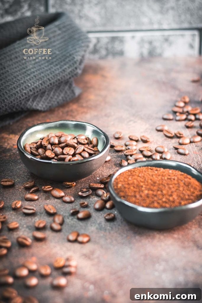 Two bowls each filled with coffee beans and grated coffee on rust brown background surrounded by coffee beans.