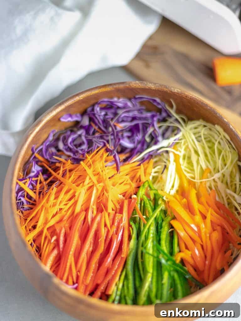 rainbow cabbage salad in wooden bowl next to cutting board