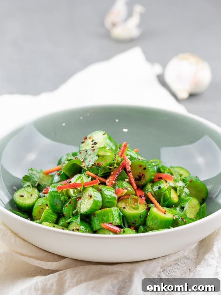 Spicy Asian Cucumber Salad Recipe with Chili-Sesame Dressing 3 Spicy Asian cucumber salad with herbs and red pepper in a blue bowl