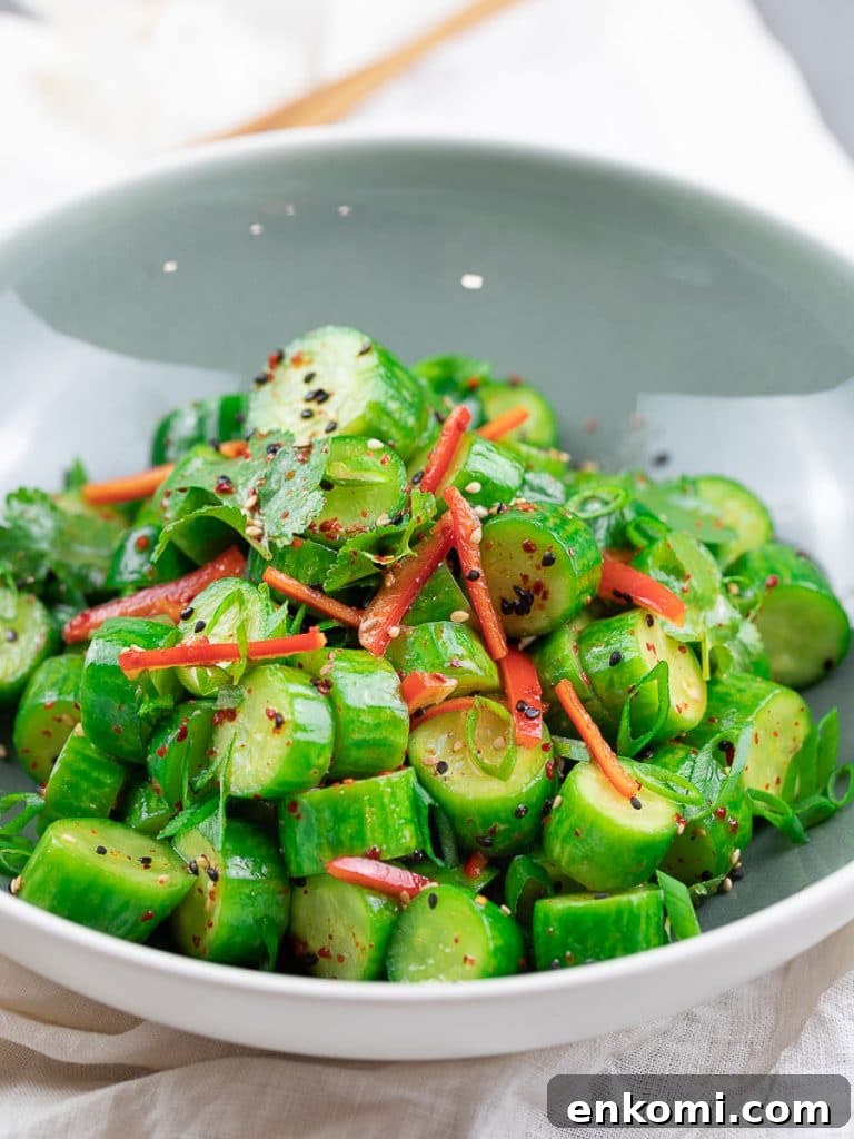 Spicy Asian Cucumber Salad Recipe with Chili-Sesame Dressing 8 Spicy Asian cucumber salad with herbs and red pepper in a blue bowl