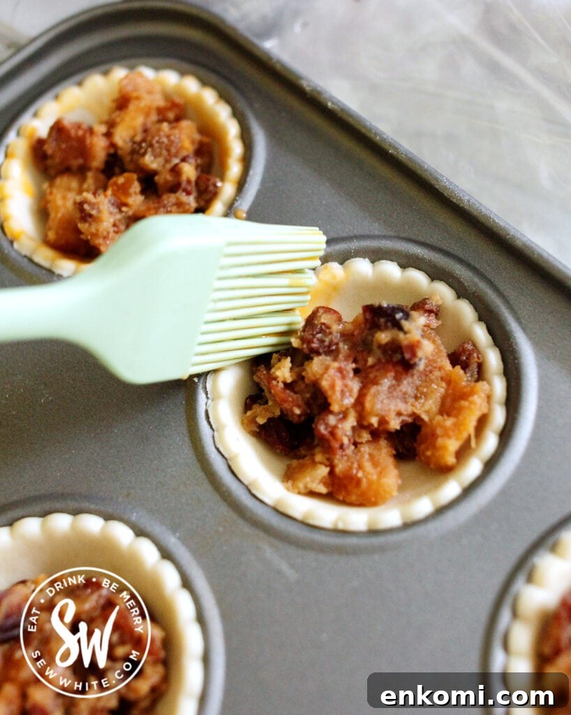 egg washing the shortcrust pastry with the mince pies