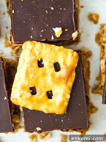 Cut up peanut butter chocolate pretzel bars with a pretzel on top.
