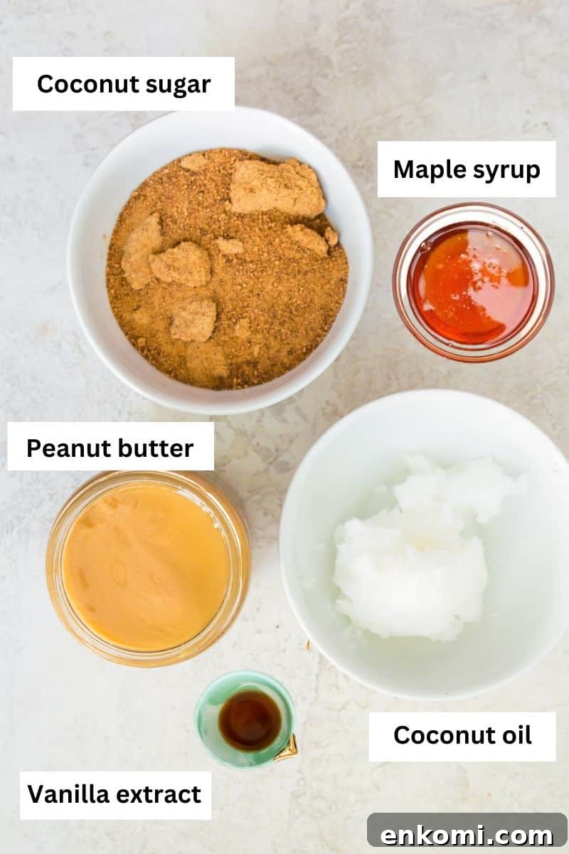 Five bowls with different ingredients in them including coconut sugar, maple syrup, peanut butter, coconut oil and vanilla extract.