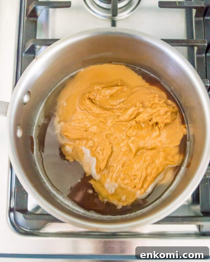 A pot with peanut butter, maple syrup and coconut oil in it.