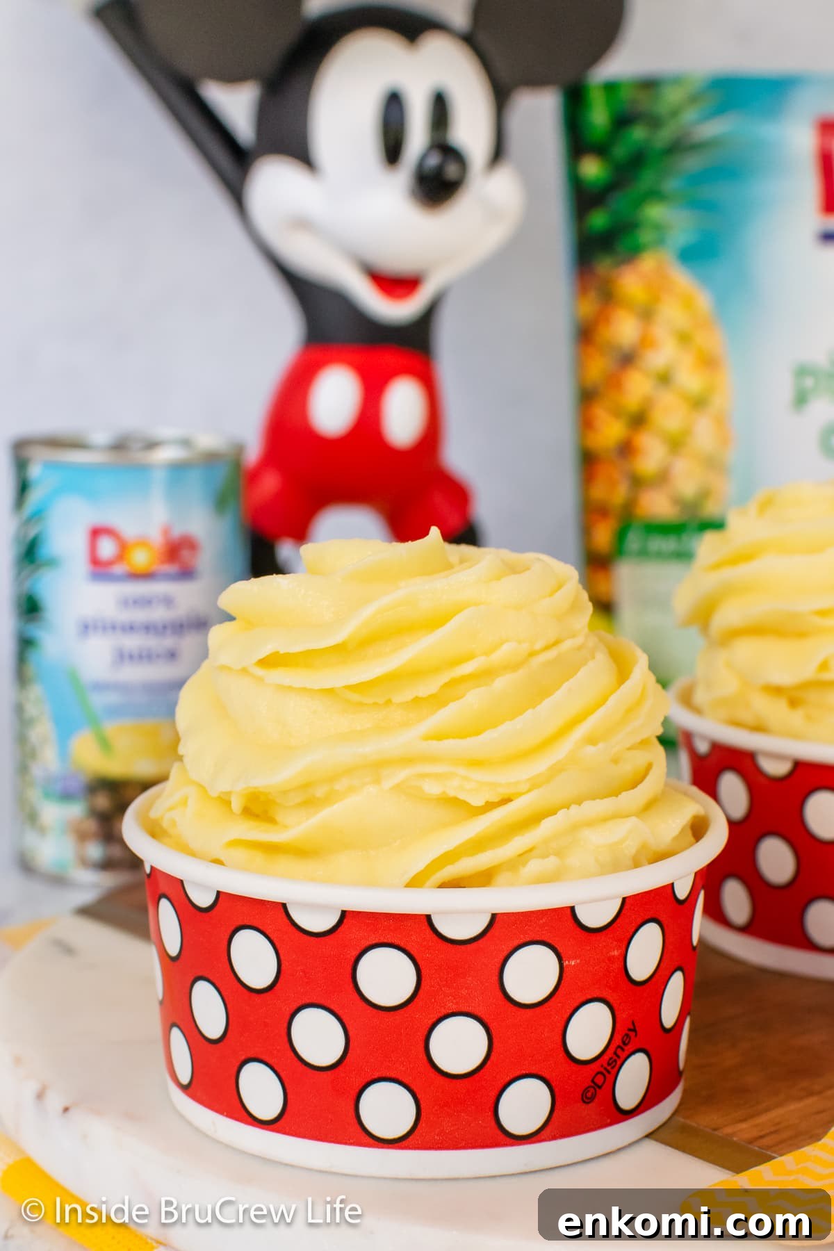 Homemade Pineapple Dole Whip Recipe — Creamy Tropical Soft Serve 2 A swirl of pineapple whip in a red and white polkadot cup.