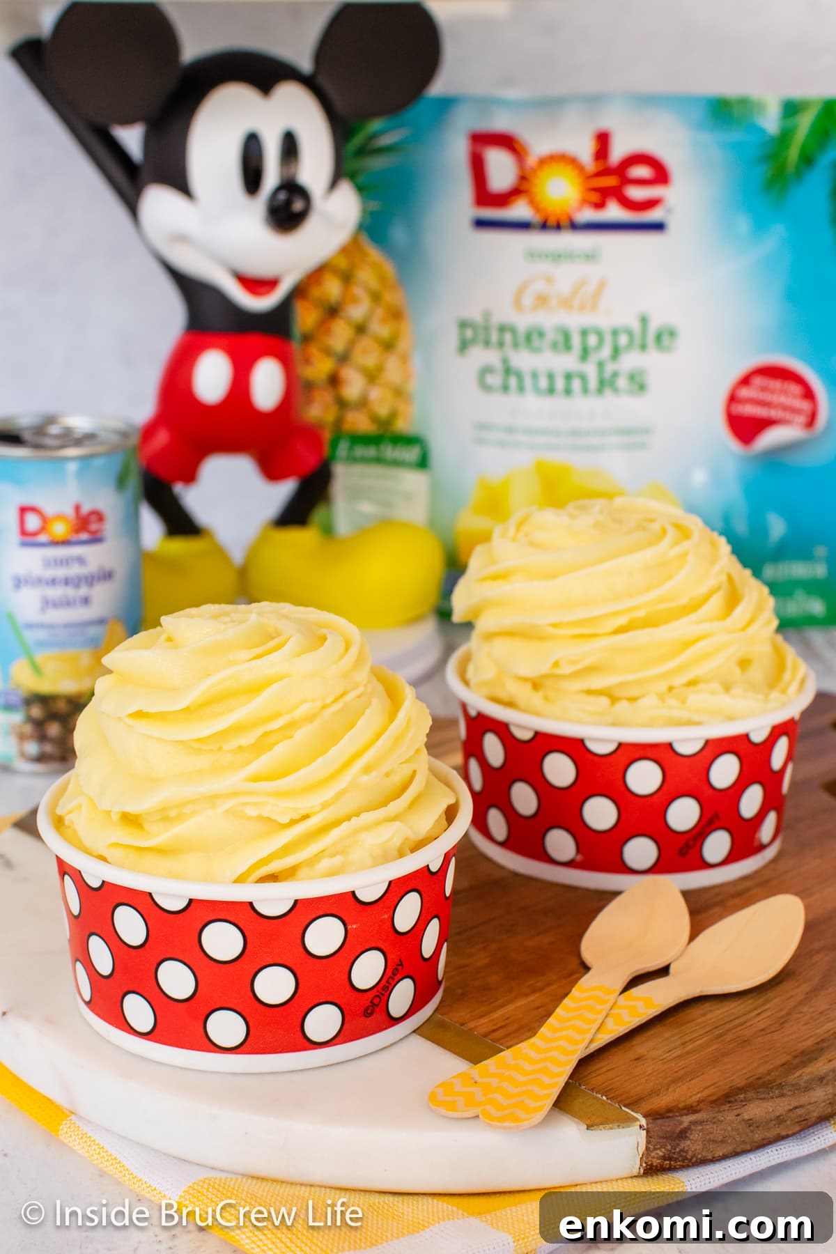 Homemade Pineapple Dole Whip Recipe — Creamy Tropical Soft Serve 6 Two paper cups filled with a swirl of pineapple sorbet.