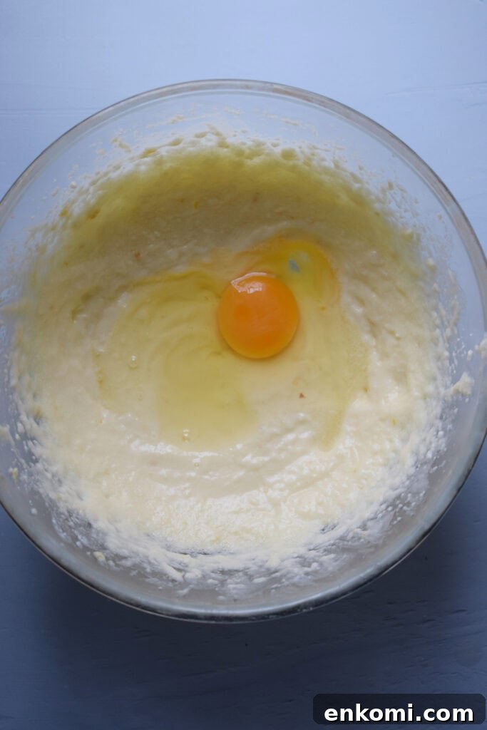 Adding an egg to cookie batter.