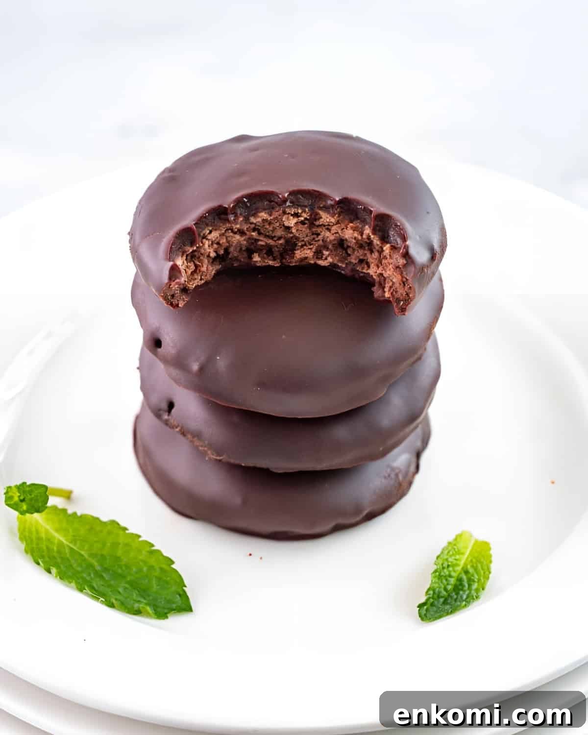 a bitten thin mint cookie on a stack of 3 more cookies.