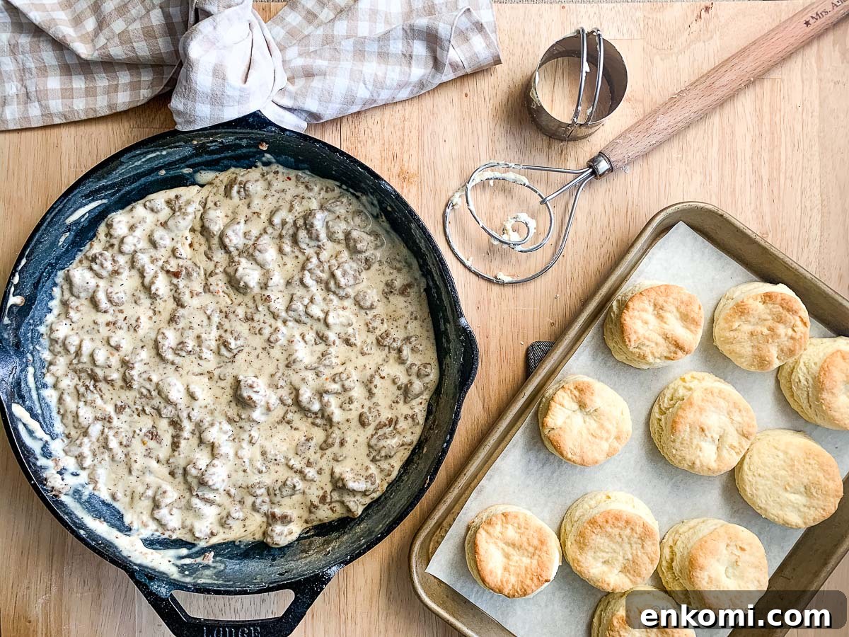 Creamy Sausage Gravy for Biscuits: Homemade Southern Recipe 3 a cast iron skillet of gravy sausage with a pan of freshly baked biscuits.