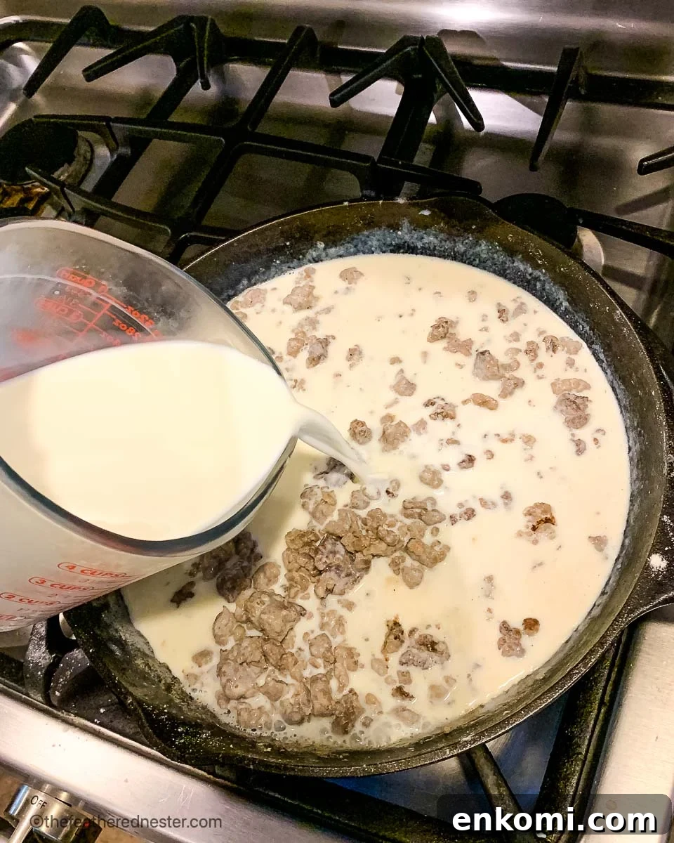 Creamy Sausage Gravy for Biscuits: Homemade Southern Recipe 5 pouring milk into a cast iron skillet.