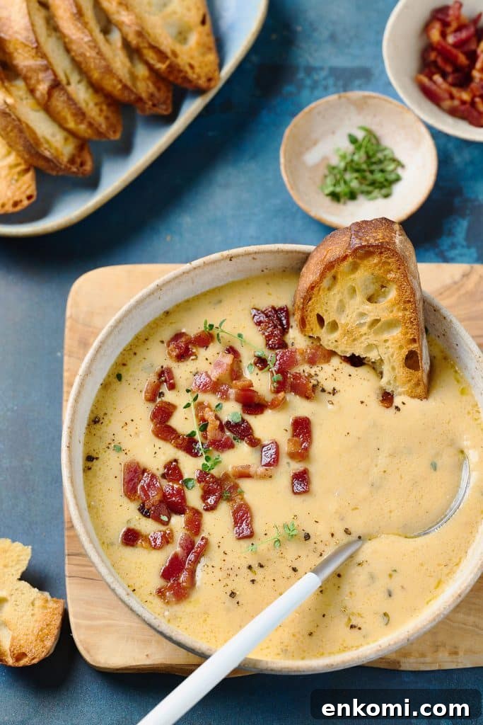 Spoon in a bowl of creamy soup served with rustic bread