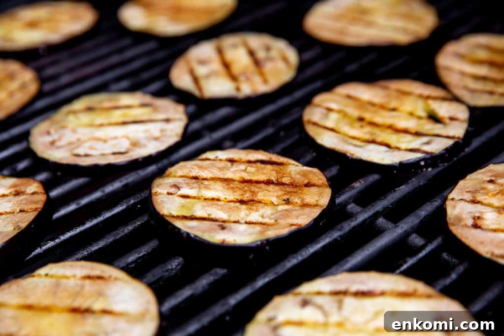 Greek-Style Grilled Eggplant Salad with Simple Grilling Tips 6 Eggplant slices with grill marks on a grill.