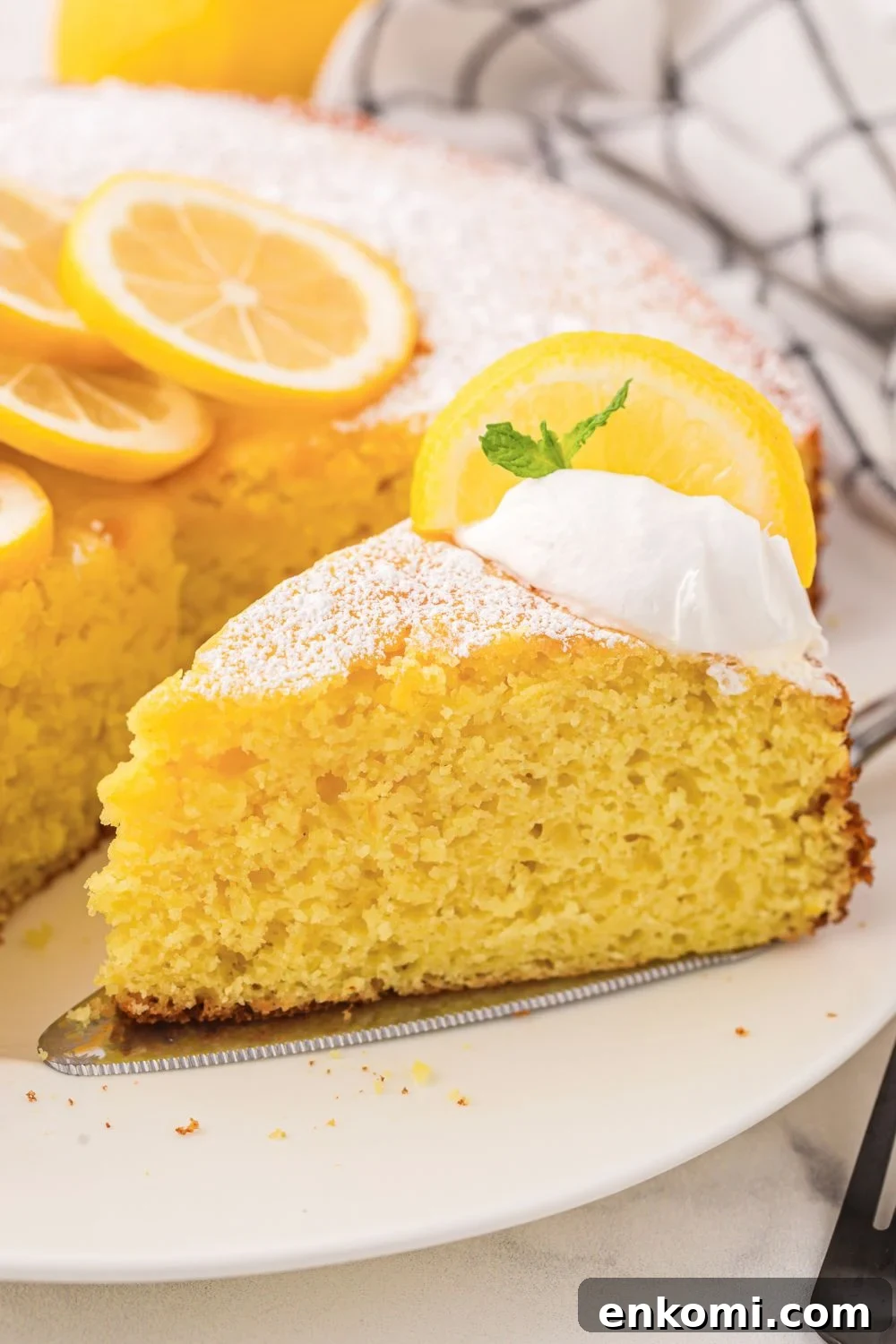 Italian Lemon Ricotta Cake on plate with a slice taken out of it 