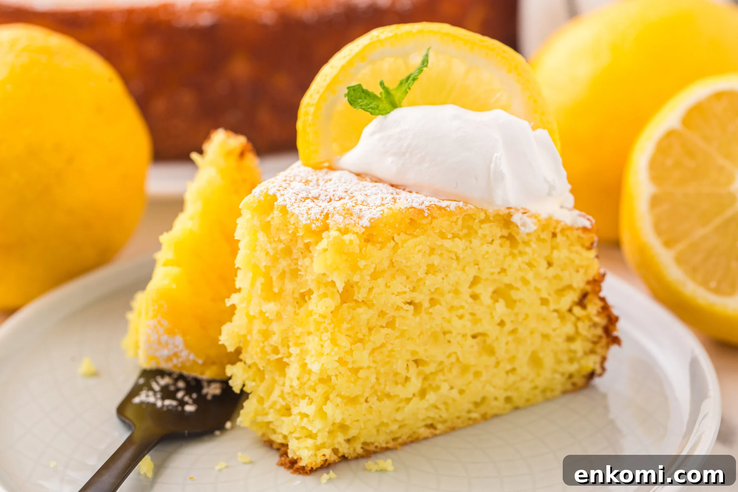 slice of Italian Lemon Ricotta Cake on a white plate with a fork taking a bite out of the slice 