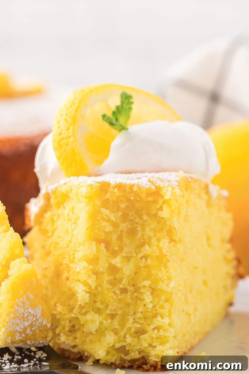 slice of Italian Lemon Ricotta Cake with a fork bite taken out of it on a plate on table 