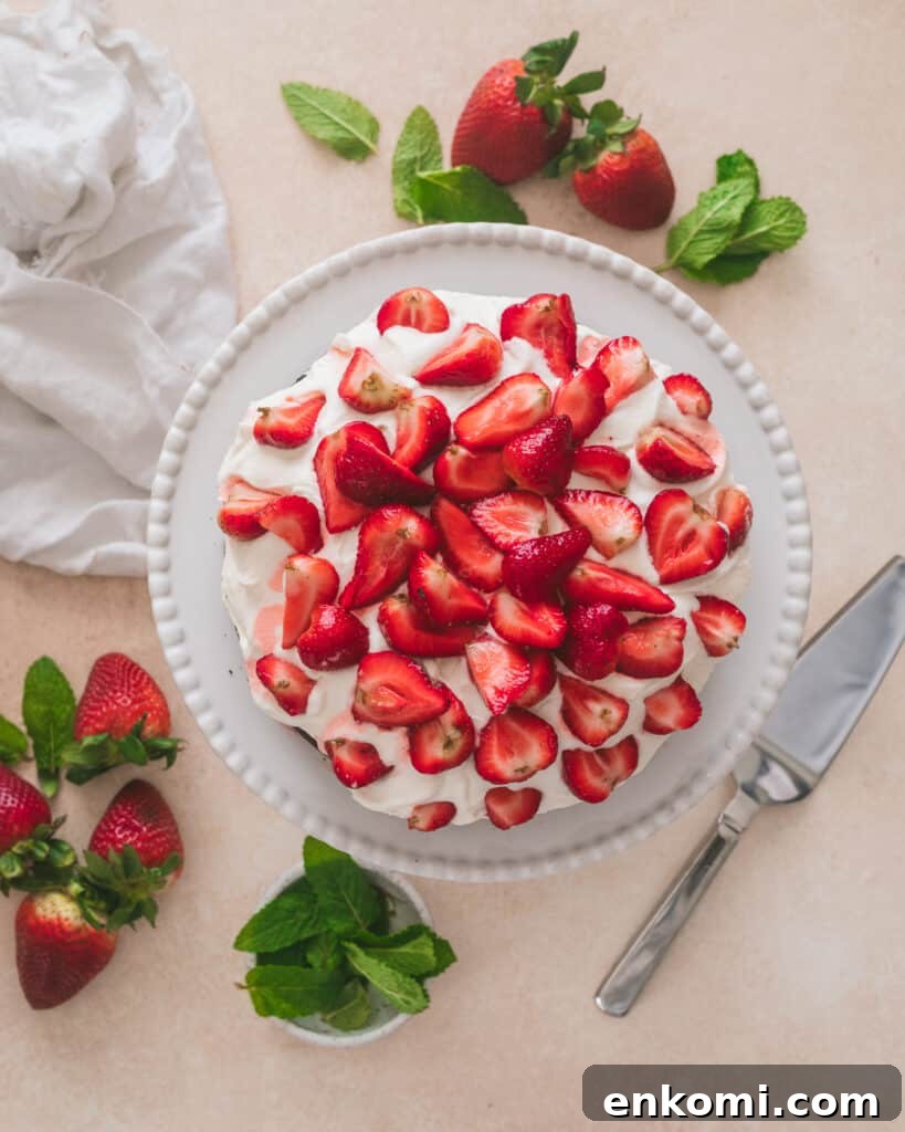 Strawberry and Cream Chocolate Layer Cake Recipe 2 Strawberries and cream chocolate cake on a cake stand with a cake cutter
