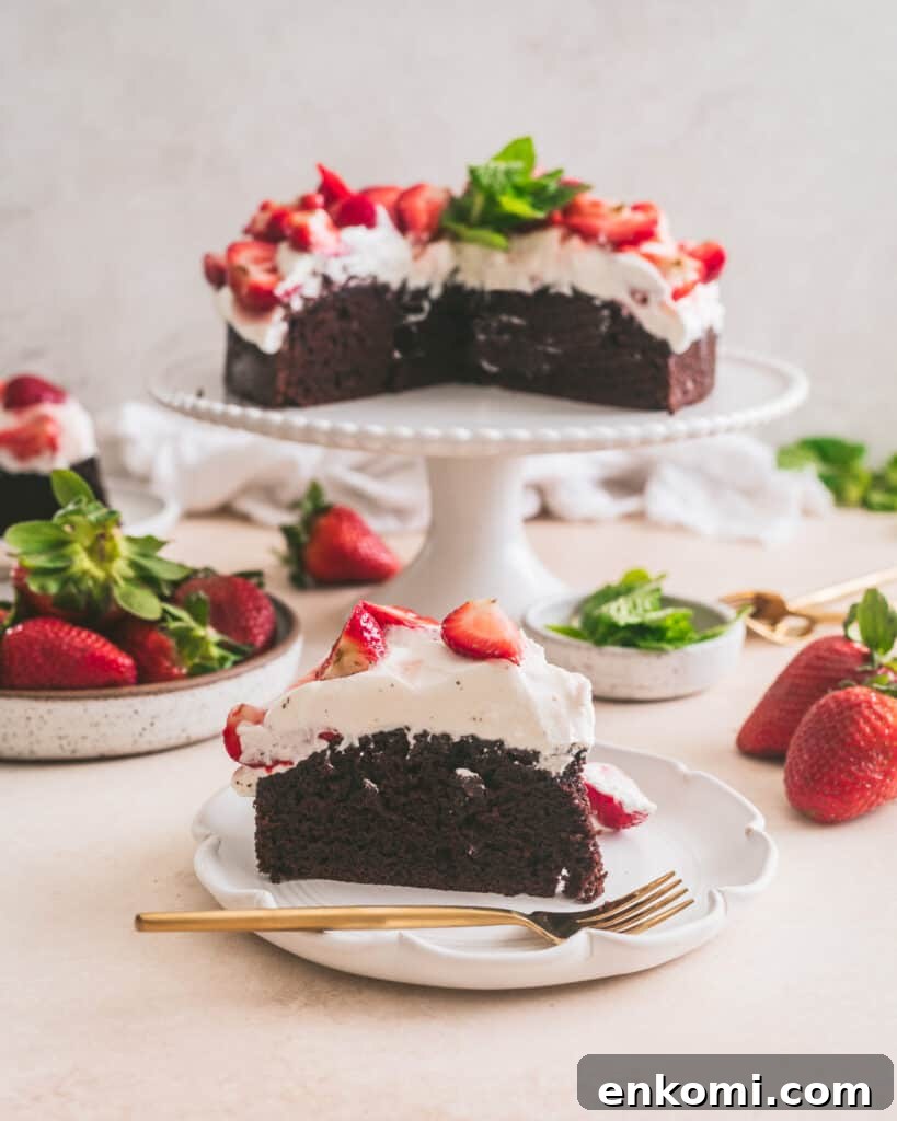 Strawberry and Cream Chocolate Layer Cake Recipe 3 Chocolate cake on a plate with cake on cake stand in the background