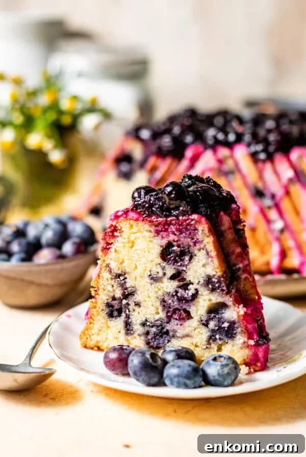 Strawberry and Cream Chocolate Layer Cake Recipe 8 a slice of lemon blueberry pound cake on a cake plate topped with blueberry lemon glaze and blueberry compote on top.