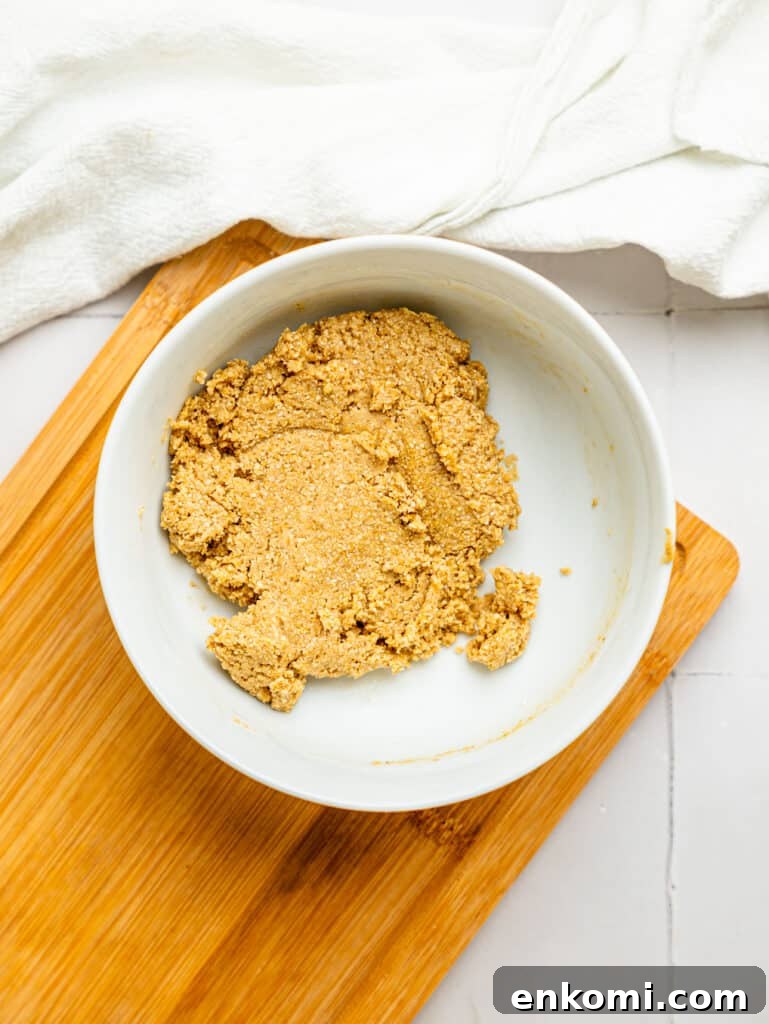 High-Protein Mini Cheesecakes: Low-Calorie Dessert Recipes 7 Cheesecake crust ingredients combined in a bowl.