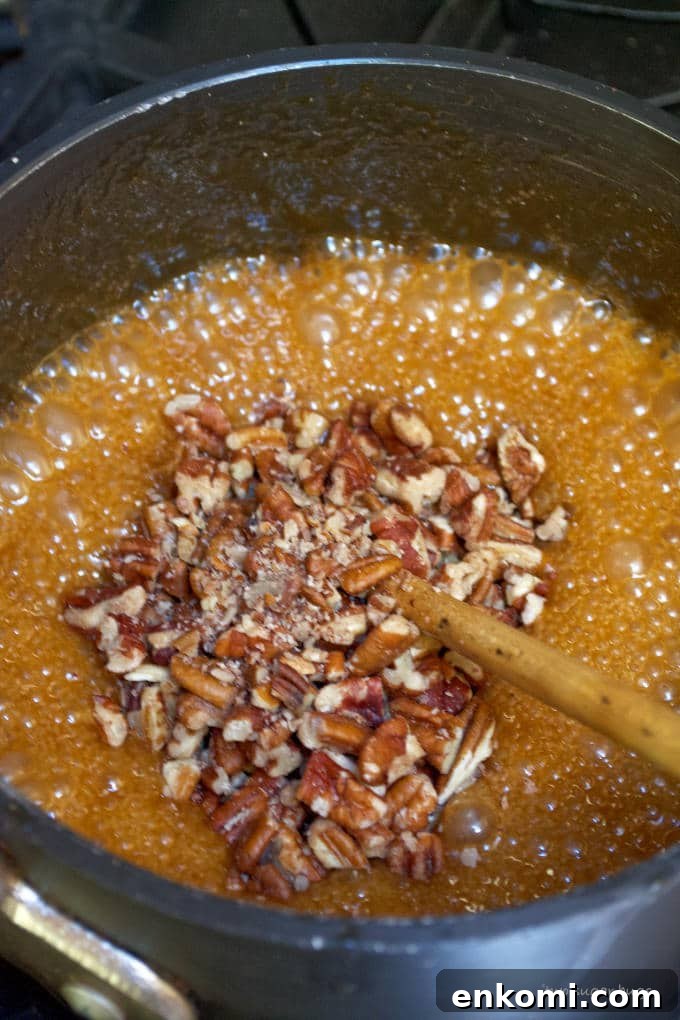 pecans being mixed into caramel sauce